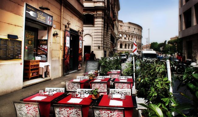 Ingresso e tavoli esterni con il Colosseo sullo sfondo, vicino al Colosseo